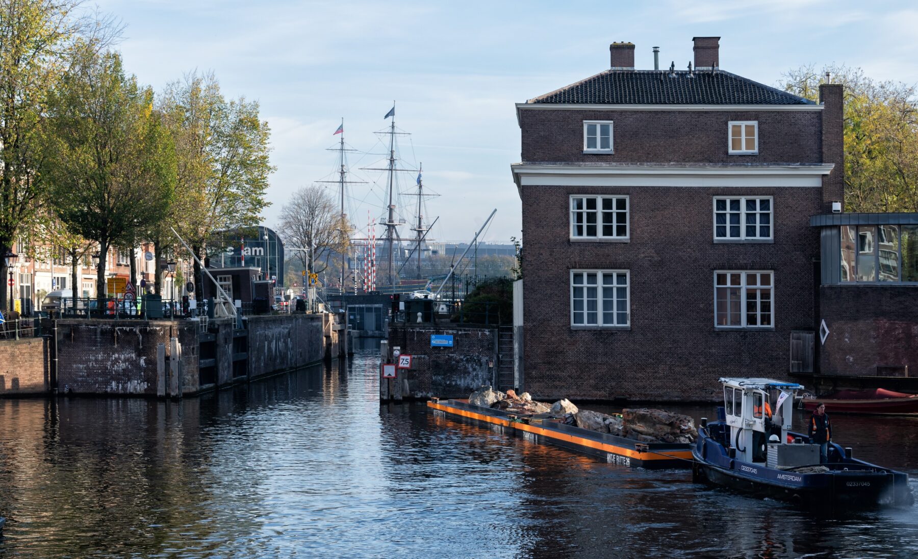 Boot voert stukken gesloopte kademuur af bij de Nieuwe Herengracht
