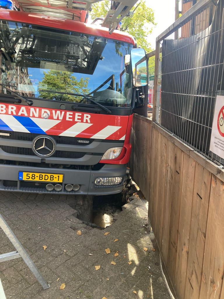 Een bandweerauto is weggezakt in een zinkgat aan de Lijnbaansgracht