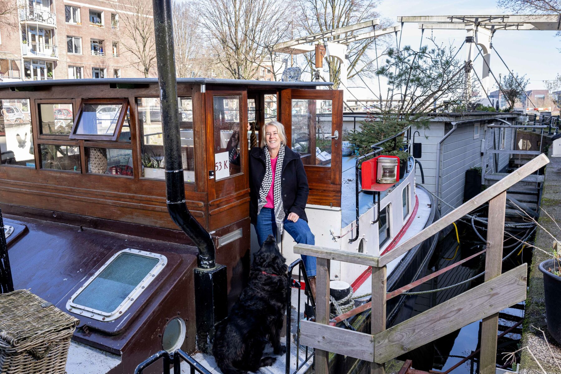 Barbara Jurgens op haar woonschip aan de Zoutkeetsgracht, met op de achtergrond de Petemayenbrug