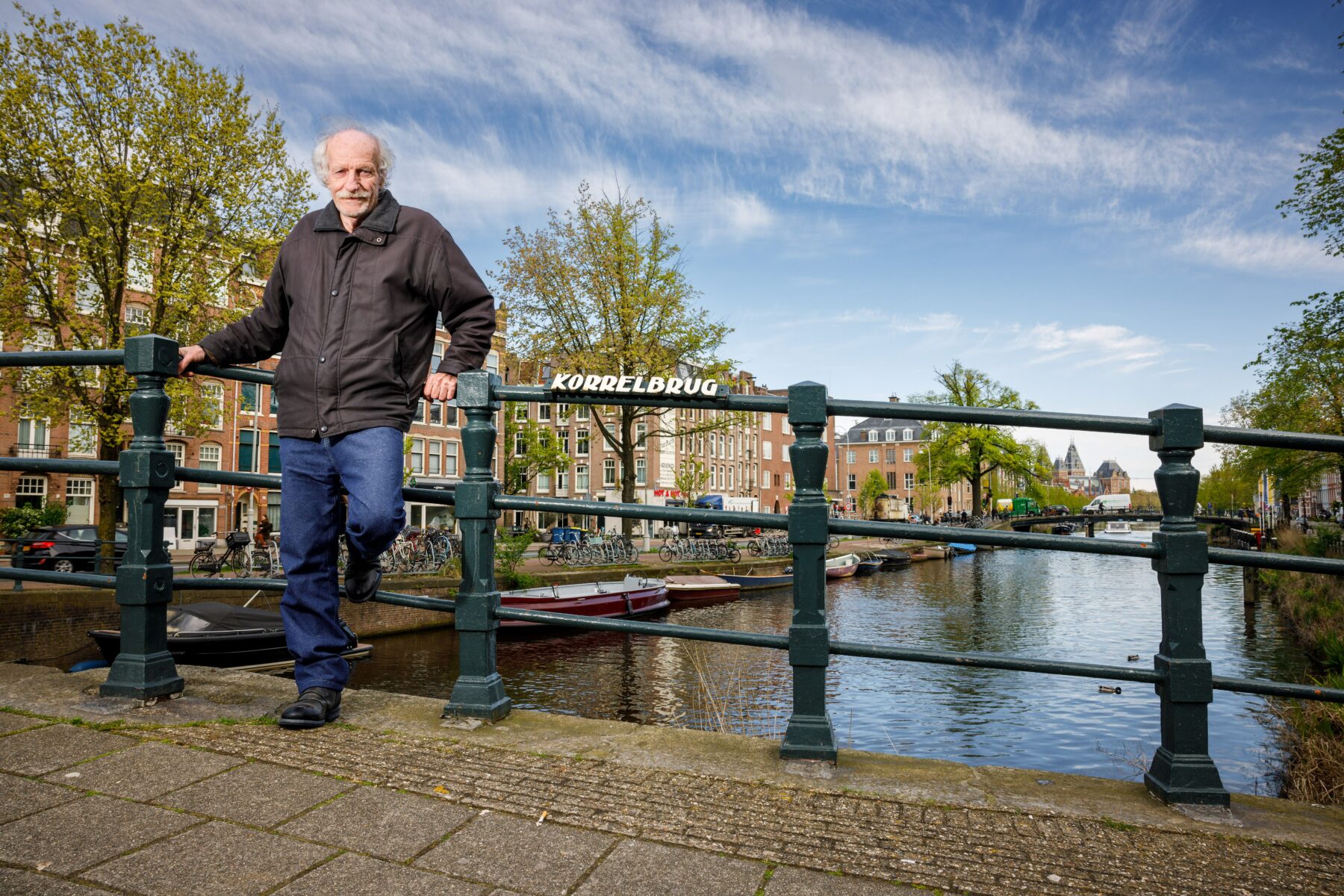 Peter Korrel op de naar zijn familie vernoemde brug. In de verte zie je nog een stuk van het Rijksmuseum.