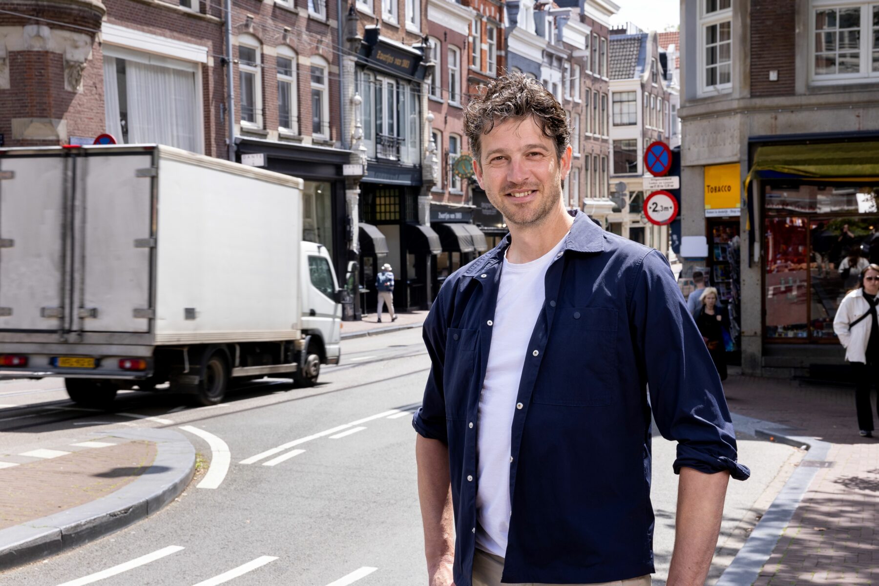 Portretfoto van Frederick van Waarde met op achtergrond een klein vrachtwagen op de Utrechtsestraat