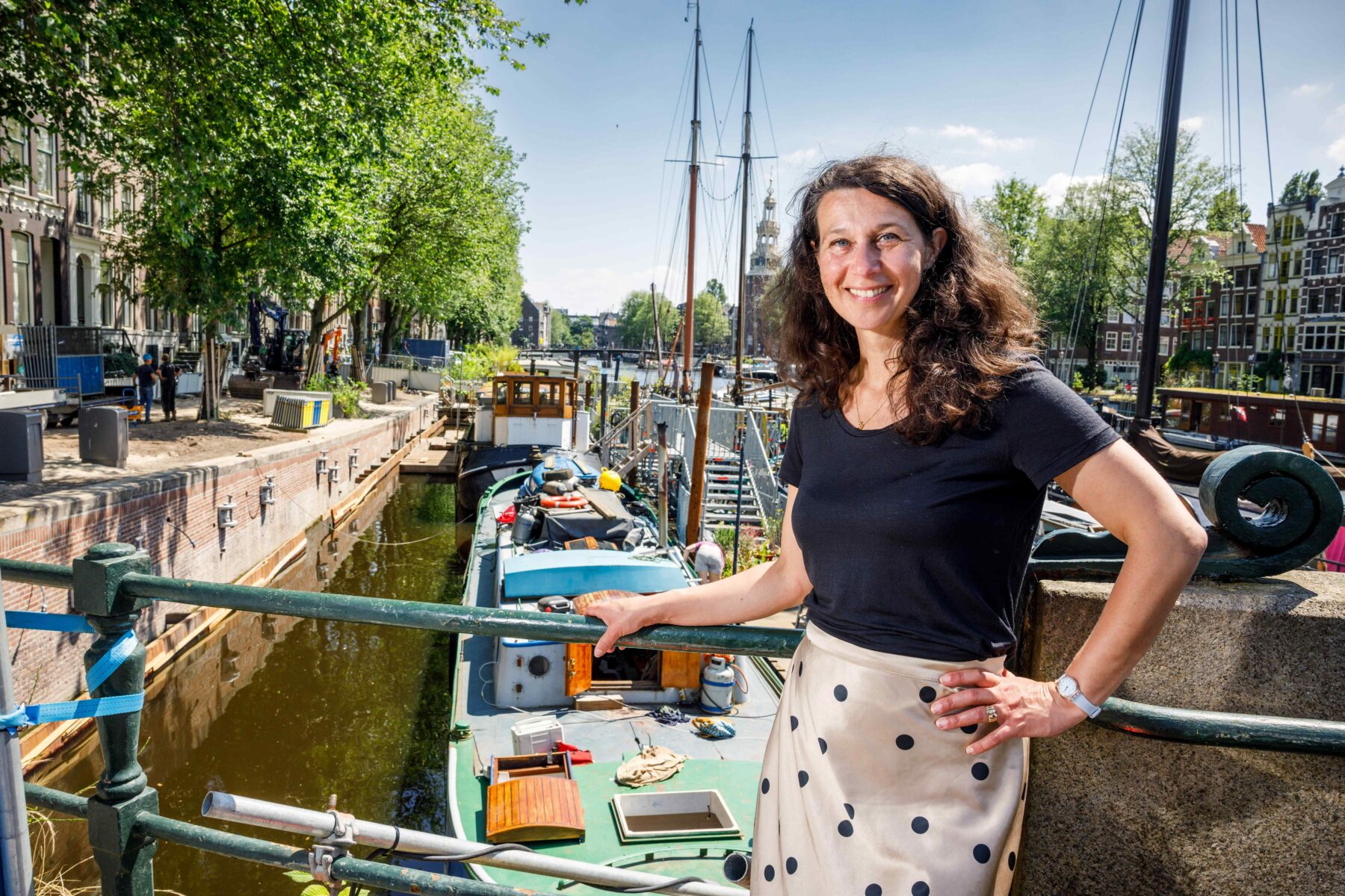 Portret van omgevingsmanager Angela Nijland op een brug over de Waalseilandsgracht