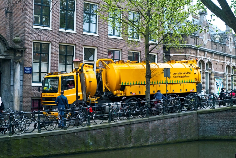 Een zware kolkenzuiger op de Oudezijds Achterburgwal in de Amsterdamse binnenstad