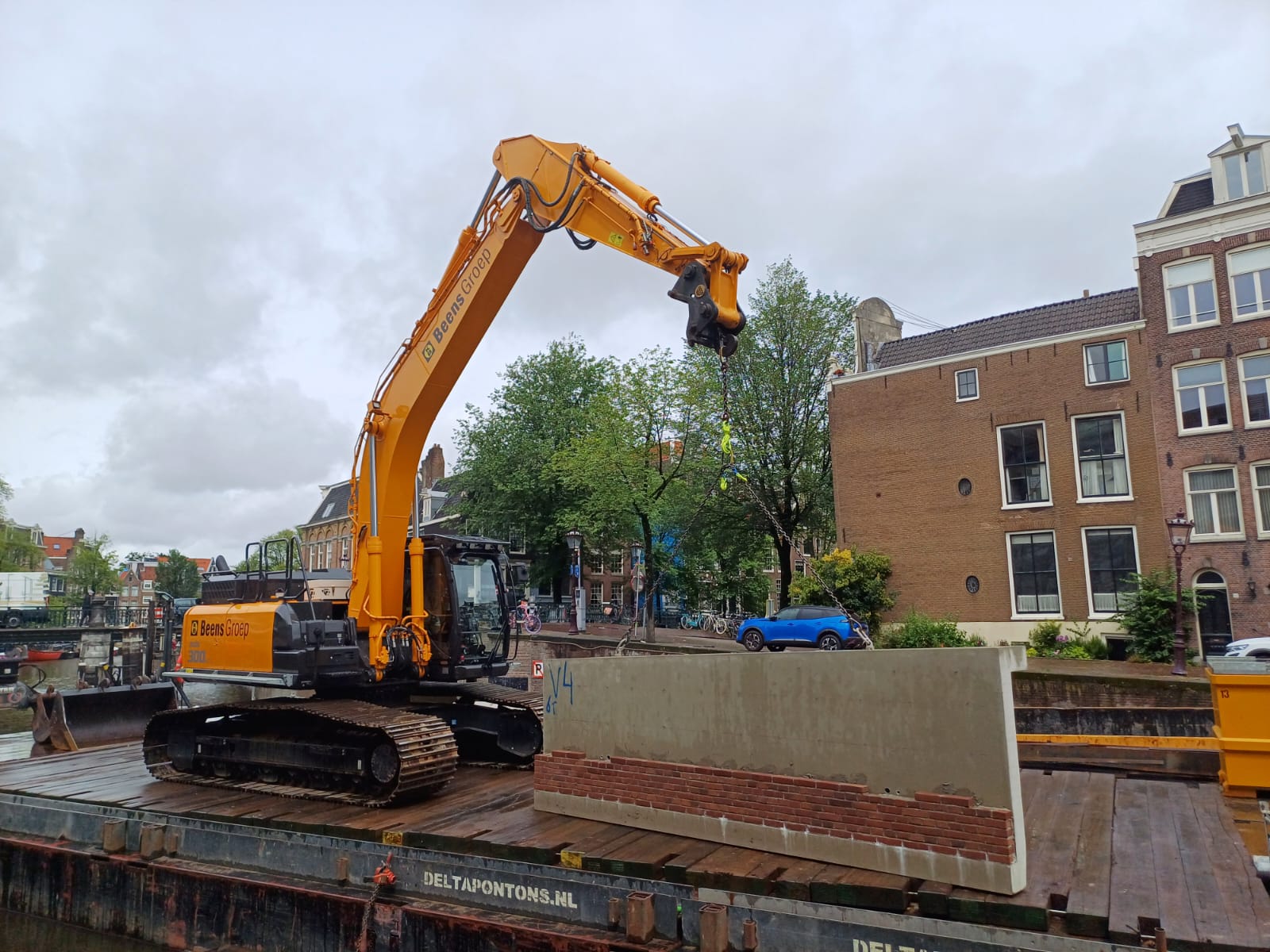 Kraan op ponton in de gracht met een prefab betonnen damwand