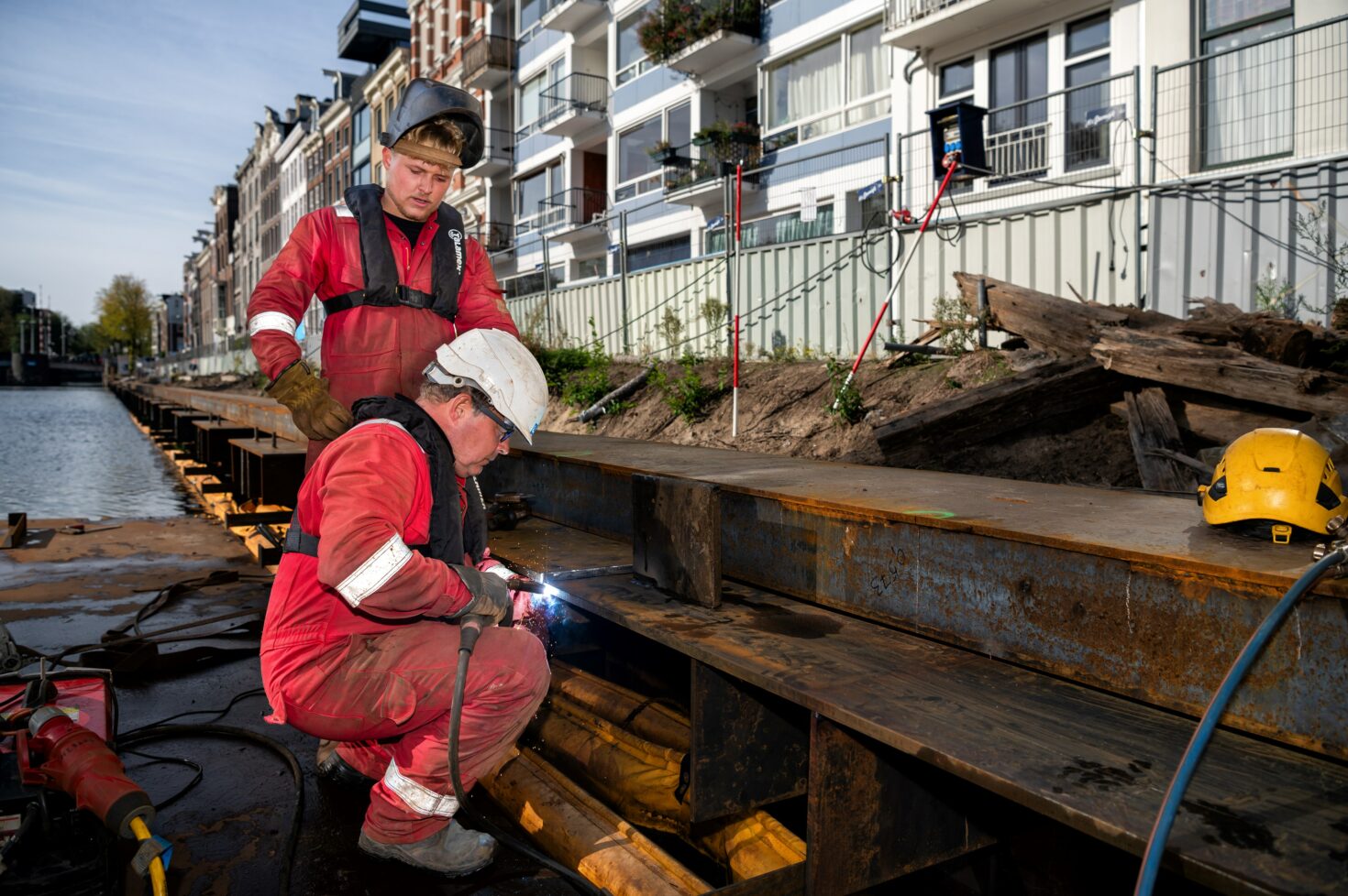 Vader Ron Dobber last, terwijl zoon Rick toekijkt op het werk aan de Nieuwe Herengracht