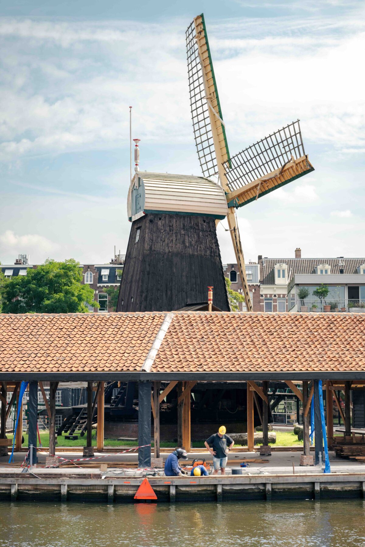 Molen de Otter met op de voorgrond de monumentale droogloodsen voor het hout