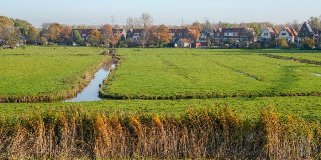 Beeld van weilanden met slotenpatroon net buiten Amsterdam