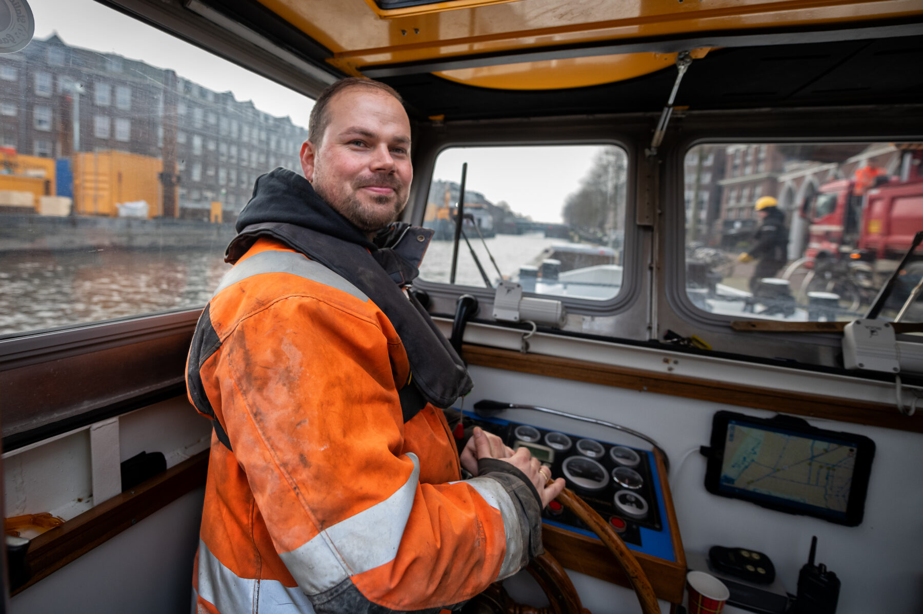 Schipper Lubbert vaart behendig met een grote duwbak vol bouwmateriaal door de Amsterdamse grachten.