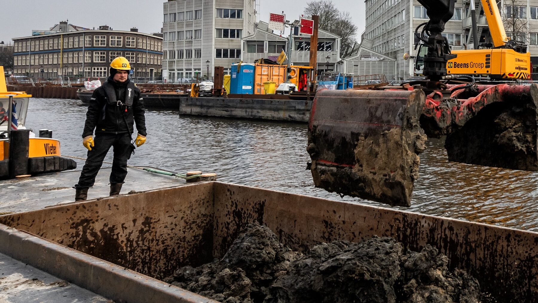 Meini Ras helpt bij het overladen van klei naar de schuit op de bouwlocatie aan de Kostverlorenkade