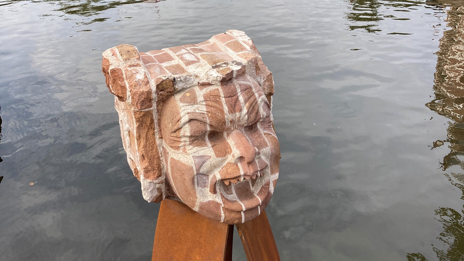 Beeld van de Bullebak in het water bij de brug, gehakt uit een brok baksteen van de gesloopte Bullebakbrug
