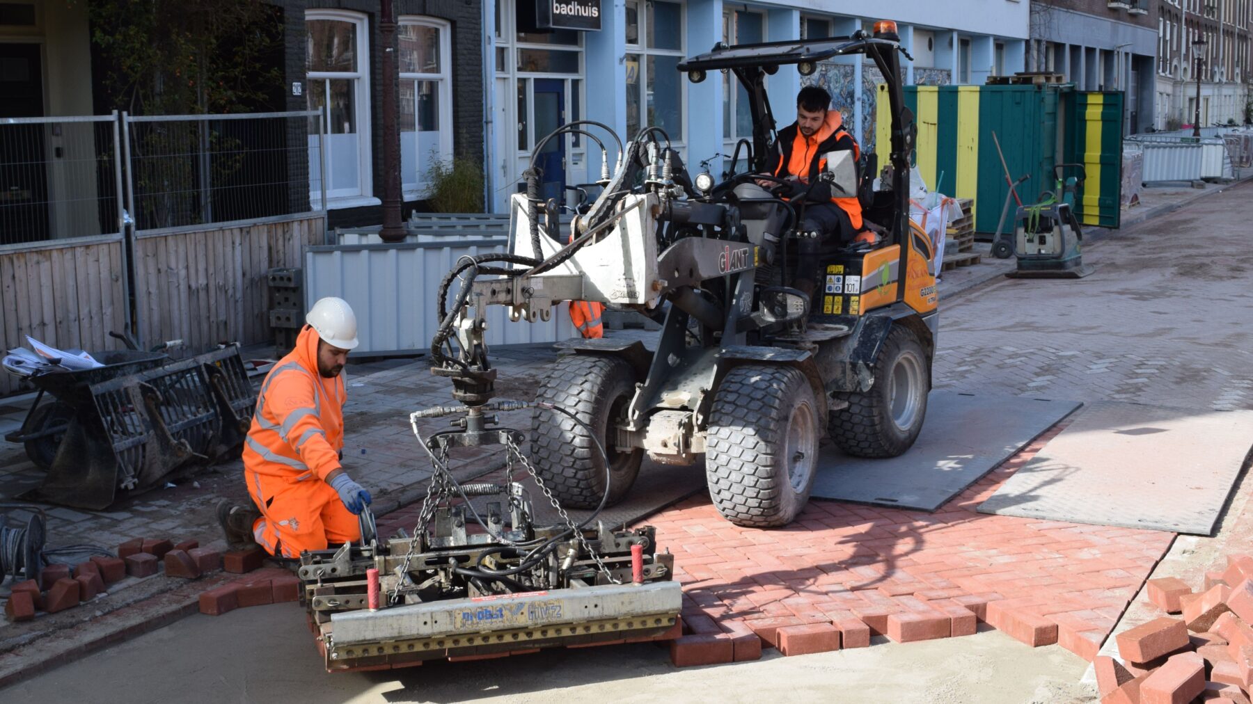 Meerdere straatstenen worden neergelegd met een machine