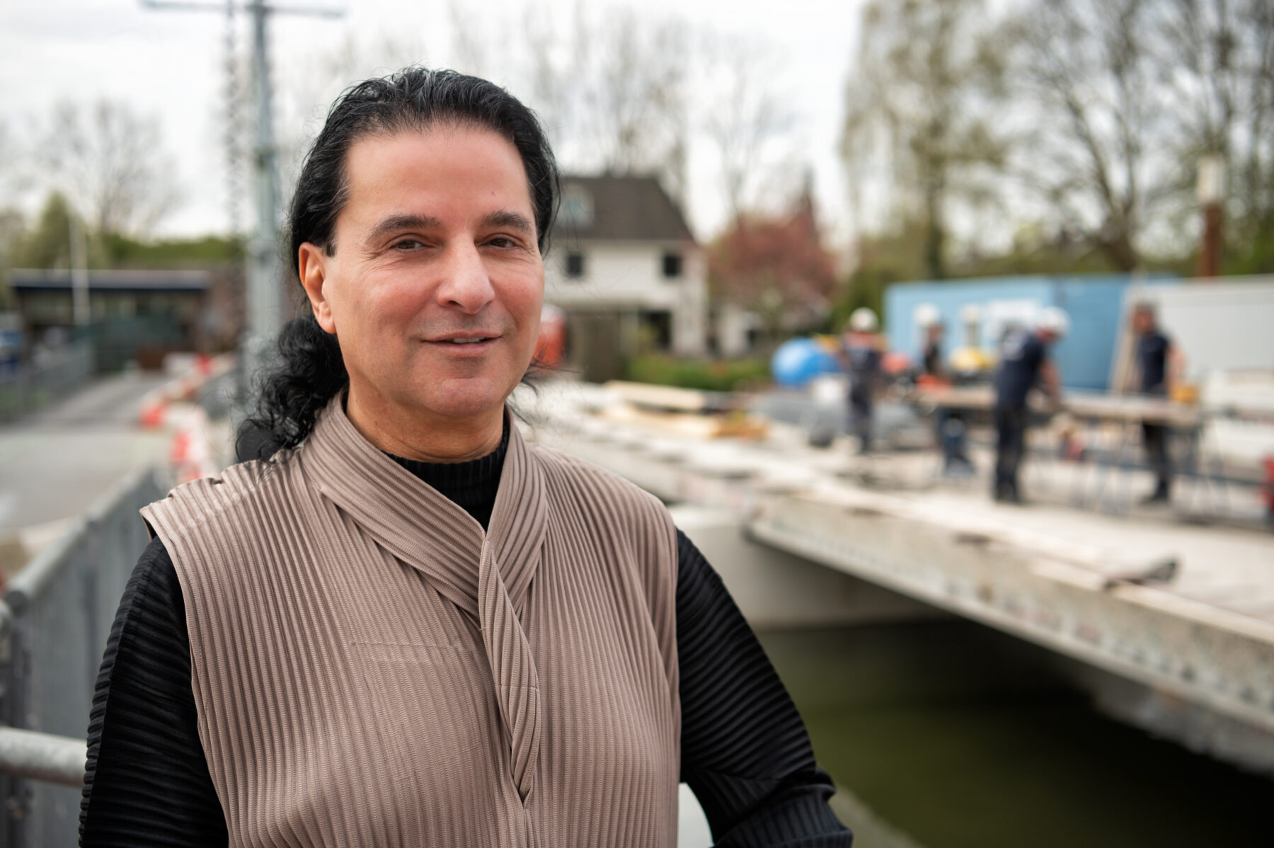 Projectleider Hassan El Arif met op de achtergrond de Fortbrug in Weesp