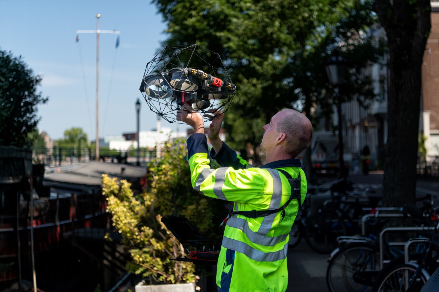 Man houdt drone vast aan de kade van de Amstel