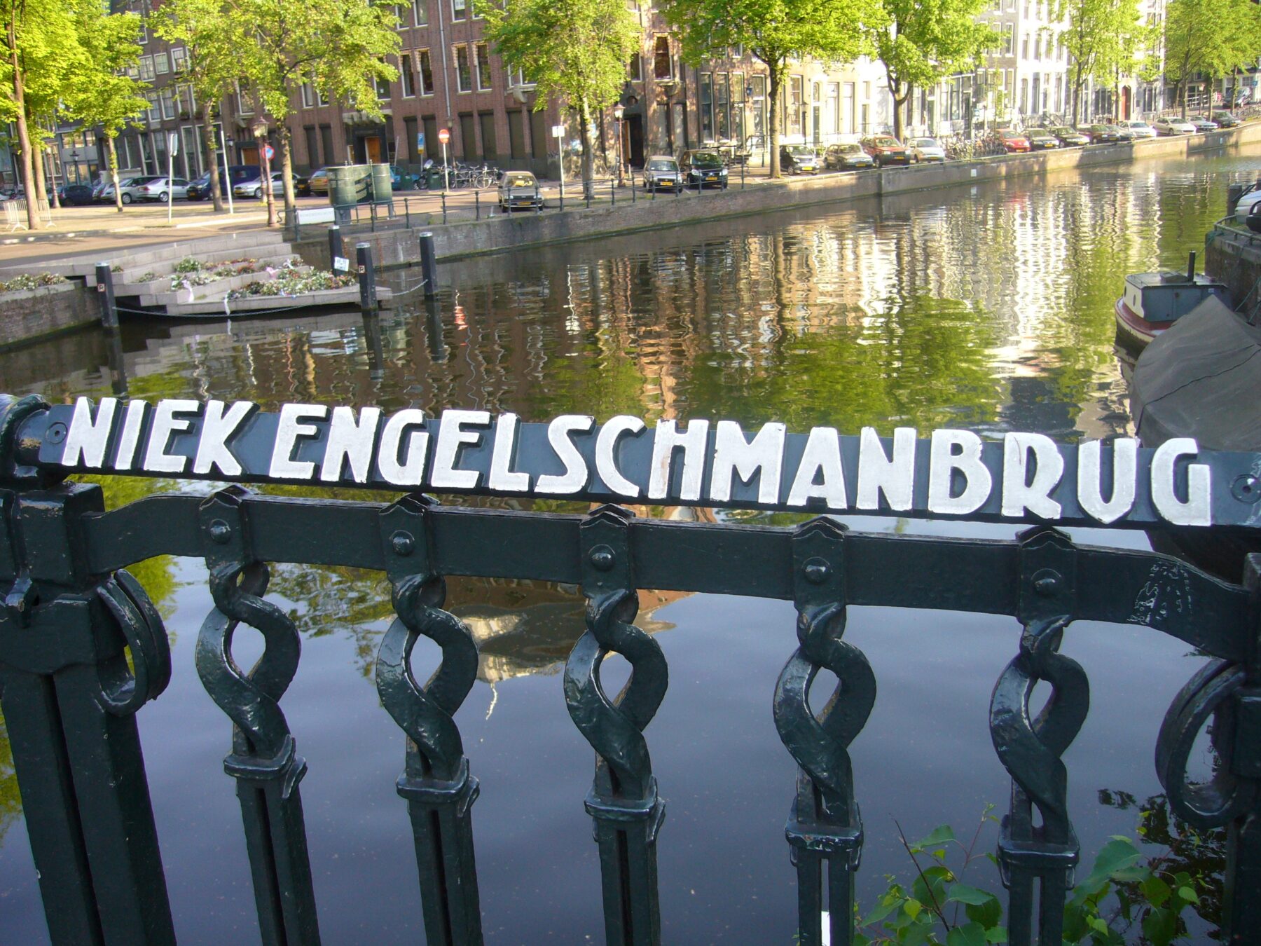 Naamplaatje Niek Engelschmanbrug op de voorgrond, het homomonument op de achtergrond
