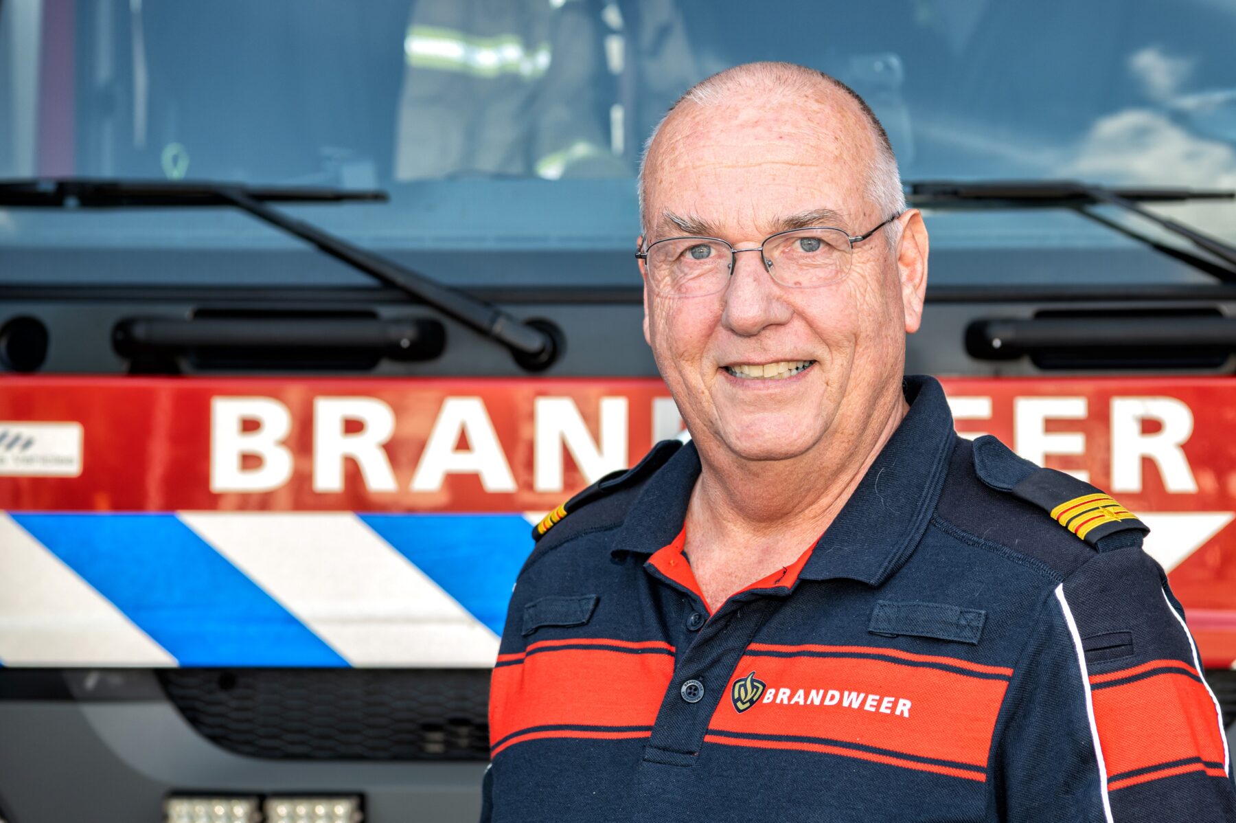 Portret van Nico Theuns voor een brandweerauto