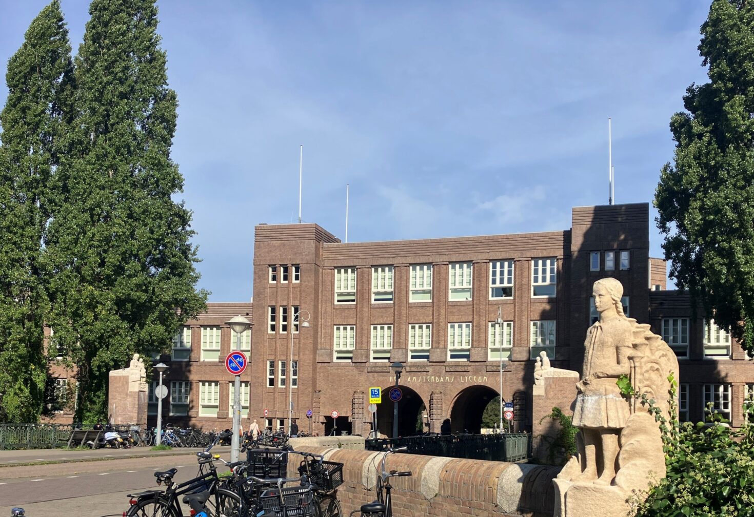 De Lyceumbrug richting het Amsterdamse Lyceum. Op de voorgrond een beeld van een schoolmeisje